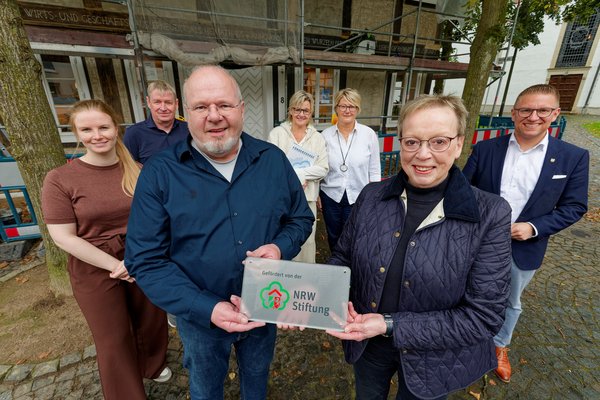 Auf dem Foto vorne von links: Marianne Thomann-Stahl (Vorstandsmitglied Förderverein  NRW-Stiftung) und Matthias Holzmeier (Vorsitzende Heimatverein Verl) Hinten von links: Lena-Marie Koch (Untere Denkmalbehörde Stadt Verl), Martin Wanders (Gebäudemanagement Stadt Verl), Beate Behlert (Heimatverein Verl), Martina Peterhanwahr (Heimatverein Verl) und Robin Rieksneuwöhner (Bürgermeister Stadt Verl).