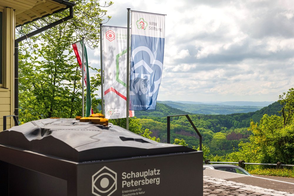 Tastmodell am Schauplatz Petersberg mit wehenden Fahnen im Hintergrund