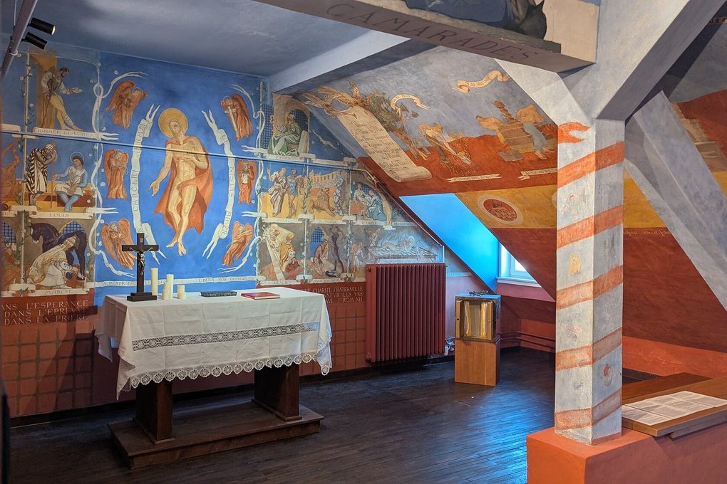 Blick auf die von den Gefangenen Offizieren erstellten Wandmalereien der Kapelle. Auch die anderen Wände sind farbenfroh gestaltet.