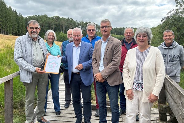 Übergabe Förderungurkunde (vorne von links): Reinhold Müller (Eifelverein Dahlem), Prof. Dr. Karl-Heinz Erdmann (NRW-Stiftung), Jan Lembach (Bürgermeister) Marita Schramm (Ortsbürgermeisterin) zusammen mit Unterstützern des Eifelvereins.